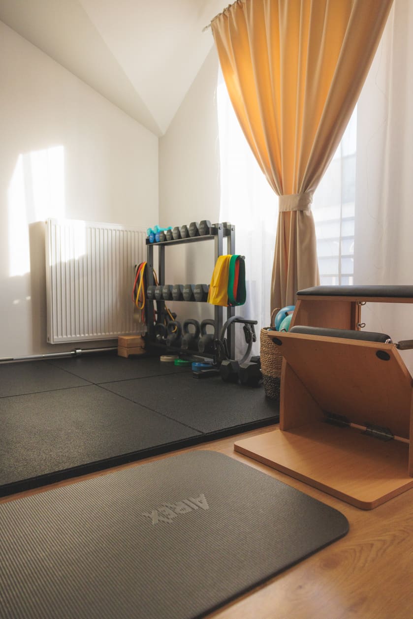 Strefa pracy na macie przy oknie, obok krzesło do Pilatesu
